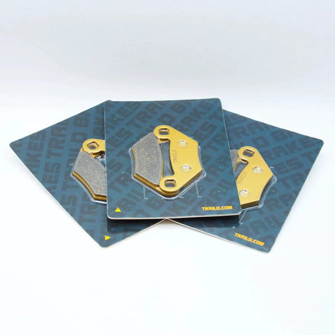 Three ceramic brake pad assemblies for Polaris Sportsman 850/570/550/450 (2009–2026), front & rear, on Traild cards.