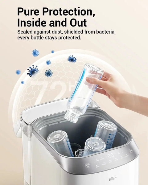 Front view of Bear Bottle Washer Pro; white/silver baby bottle sterilizer and dryer with bottle being inserted.