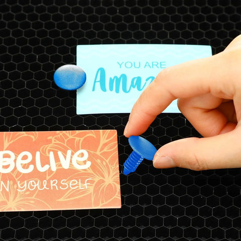 Person holding Blue Honeycomb Laser Bed Pin, part of 50 Pieces Of 7.5 To 8 Mm Hold Down Pins, on a black laser grid.