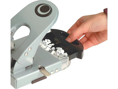 Hand removing chip bin from Heavy-Duty Two-Hole Punch With Chip Drawer, 50 Sheet Capacity, See-Through Window, Slide-Out Chip Bin For No-Muss Cleanup, Works With Standard Office Paper, Silver And Navy.
