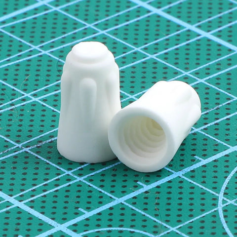 Front view of two small white ceramic wire connectors, porcelain twist caps for 22-14 AWG high-temperature wiring