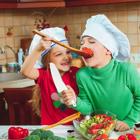 Children using Blue Wooden Kids Knife Set 11 Pieces For Little Chefs Includes Wooden Knife Serrated Toddler Knives Crinkle Cutter Sandwich Cutters Y Peeler Cutting Board And Plastic Toddler Knife For Safe Fun Kitchen Play for preparing salad in a kitchen.