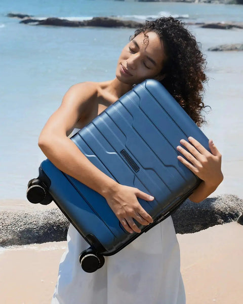Woman on beach holding Lightweight 20 Inch Carry On Luggage With Spinner Wheels For 3 To 5 Day Trips, royal blue BAGSMART.