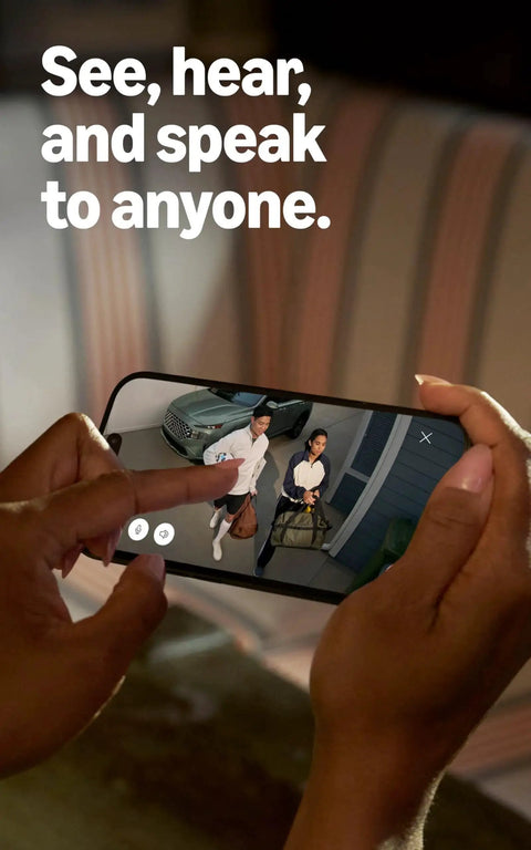 Person holding smartphone displaying video feed from Spotlight Cam Plus Battery Security Camera With HD Video Color Night Vision.