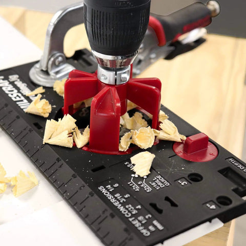Close-up of Ultimate Cabinet Jig Bundle For DIYers with drilling jig and wood shavings on black and red base