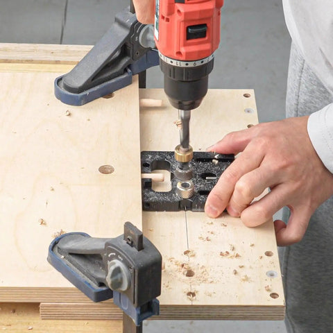 Person using Pro Shop Quality High Precision Woodworking Hole Punch Tool Dowel Jig For Accurate Hole Location In Furniture Assembly And DIY Projects Aluminum Alloy Construction For Long Lasting Performance with drill on wood panel