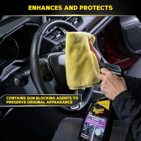 Close-up of a person using All Surface Interior Detailer That Cleans Plastics Vinyl Leather And Rubber With No Greasy Residue And Sun Blocking Protection, Spray On Wipe Off, 16 Oz Meguiars on car dashboard.