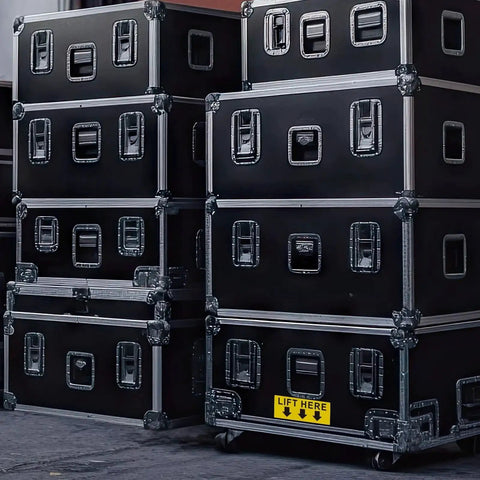 Lift Here label decal on black flight cases; bright yellow with black text and down arrows