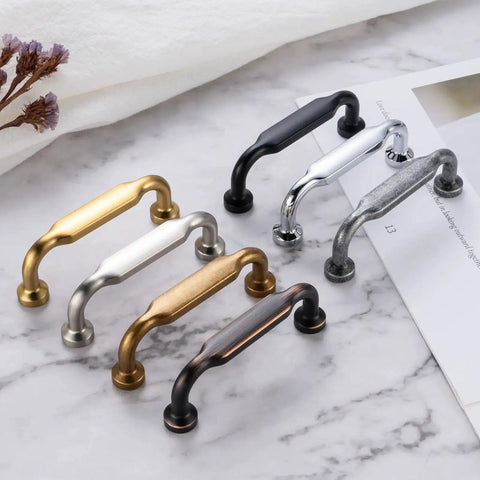 Assorted cabinet pulls on marble background, showing various finishes but focusing on Ten Pack Antique Brass Cabinet Pulls With Three And Three Quarters Inch Hole Centers For Cabinets Drawers Dressers And Vanities Heavy Duty Solid Metal Hardware With Included Screws In Size One Inch And One And One Half Inches.