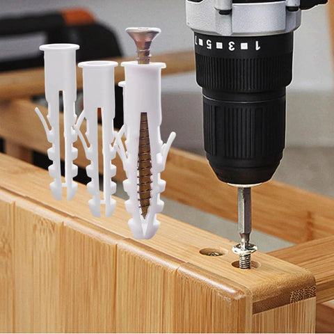 Set Of 100 White Plastic Wall Expansion Anchors 2.5 By 0.7 Cm Hollow Wall Plugs for drywall mounting next to drill.