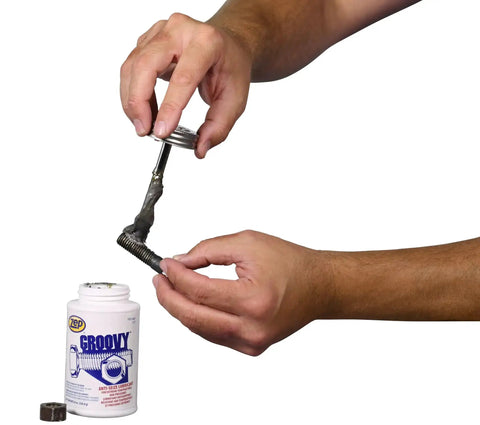 Person applying Heavy Duty Anti Seize Lubricant 8 Oz Case Of 12 Keeps Bolts From Seizing Under Heat And Rust With Long Lasting Adhesion