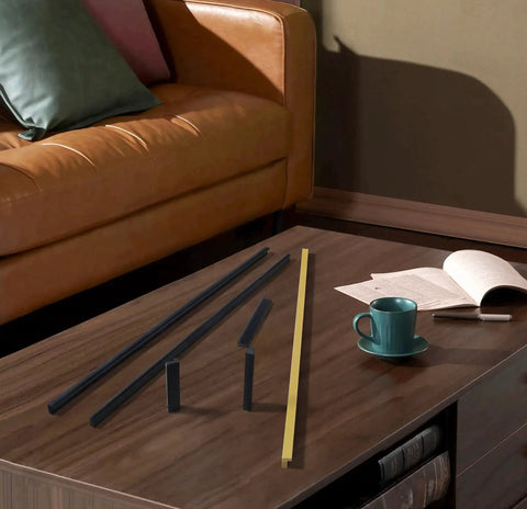 Black Tilted Aluminum Cabinet Handles 12 Pack 5 Inch 128mm on a coffee table next to a cup and book