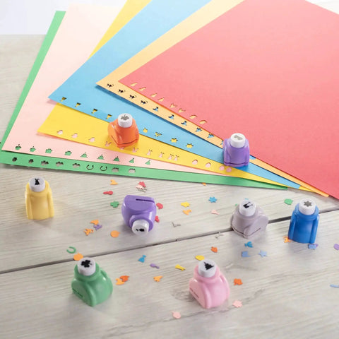 Mini Scrapbook Paper Hole Puncher Set With Forty Holiday Designs for DIY crafts on colored paper, featuring festive shapes for card making.
