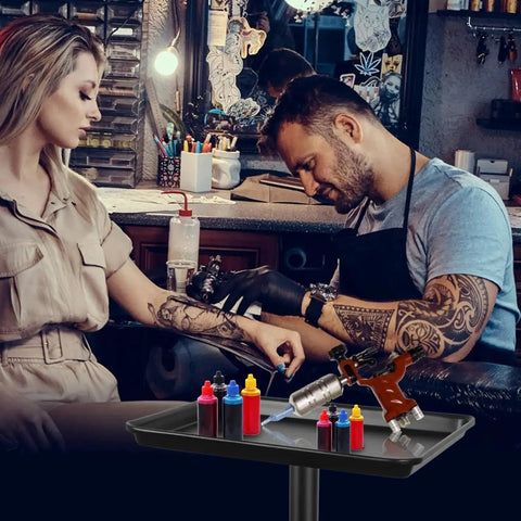Tattoo artist using the Height Adjustable Rolling Salon Tray on Wheels with Multi Level Height Range from 28 to 44 Inches, black