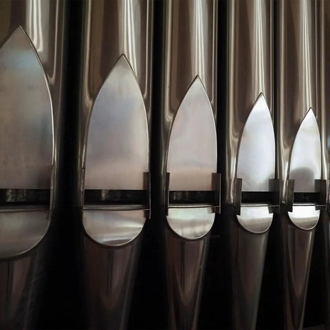Close-up of vertical stainless steel pipes with a reflective finish, part of a Five Piece 304 Stainless Steel Sheets Set With Mirror Finish.