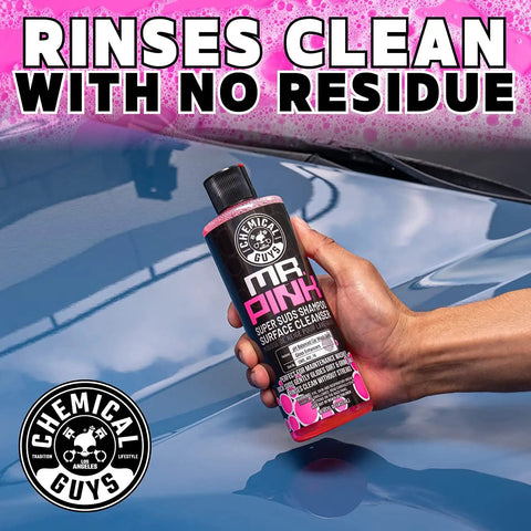 Mr Pink Foaming Car Wash Soap For Foam Cannons And Buckets Candy Scent Safe For Cars Trucks Motorcycles RVs And More 473 Ml bottle held up beside car.