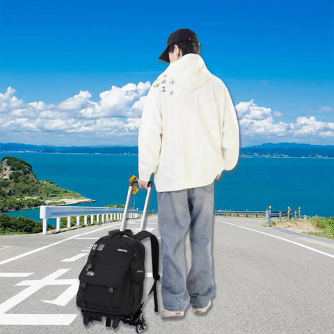 Boy with Three Piece Boys Rolling Backpack Set For School And Travel With Six Wheel Trolley Design on road overlooking ocean