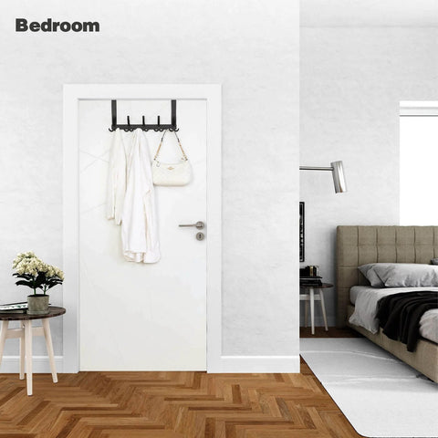 Over-the-door towel rack with 15 triple hooks in black metal mounted on white door; white robe and bag hang from hooks.