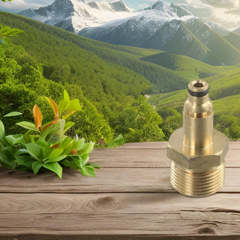 Solid brass M22 high-pressure washer hose adapter on wooden deck with greenery and mountain backdrop.