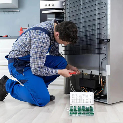 Technician repairing fridge with 270 Pcs O Ring Kit With 18 Size Assortment High Temperature Buna N Rubber Gaskets nearby on floor.