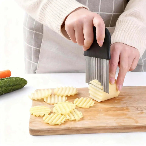 Person using Crinkle Cutter For Veggies And Potatoes With Stainless Steel Blade And Ergonomic Non Slip Handle For Easy Boss Level Veggie Prep Sharp Wave Knife For French Fries And Veggie Slicing Multi Functional Kitchen Tool For Quick Cuts And Consistent Results on potato with cutting board.