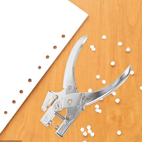 Handheld Metal Hole Puncher For Office And Crafts Single Hole Paper Punch on wooden surface with punched paper confetti