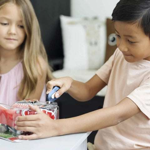Child opening toy packaging with blue Manual Retracting Ceramic Box Cutter With Safe Edge For Packaging.
