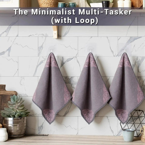 Three gray microfiber cleaning cloths hung on a kitchen wall, part of a 12 Pack Microfiber Cleaning Cloths For Cars And Home Ultra Absorbent Towels.