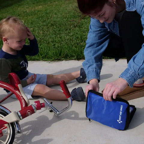 Parent using Comprehensive 298 Piece All-Purpose Emergency First Aid Kit for Home Office Car and Travel with child and bicycle.