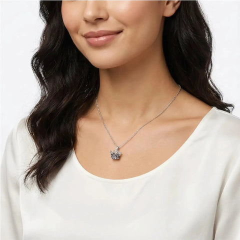 Model wearing silver necklace with large-hole vintage crown charm from 30 Pieces Mini Crown Charms Set For Crafters Mixed Color Vintage 3D Alloy King Crowns Beads Large Hole Spacer Beads For DIY Jewelry Making Necklaces And Bracelets.