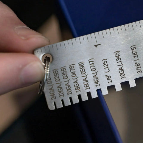 Close-up of Round Dual Sided Metal Sheet Gauge and Thickness Gauge being used, showing measurement markings on stainless steel.