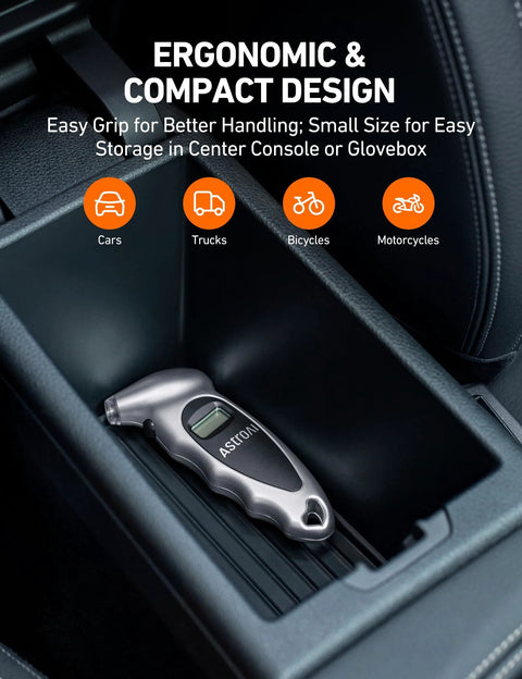 AstroAI digital tire pressure gauge, silver with backlit LCD display, placed in car center console