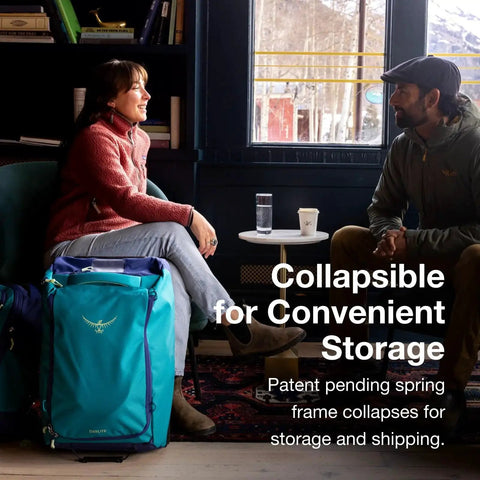 Two people sitting with Daylite 40L Wheeled Carry On Collapsible Duffel Bag in blue, highlighting collapsible storage feature.