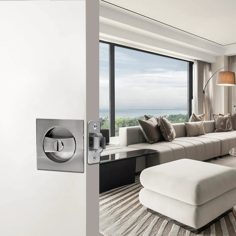 Interior view of brushed nickel pocket door lock with privacy for sliding and bifold doors, installed in a modern living room setting.