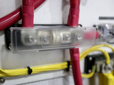 Close-up of a mounted Class T Fuse Block For Marine Electrical Systems With 320A Capacity, includes insulating cover.
