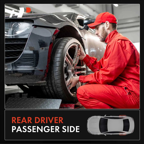 Mechanic in red uniform working on rear wheel of a car in a garage, emphasizing rear driver passenger side maintenance.