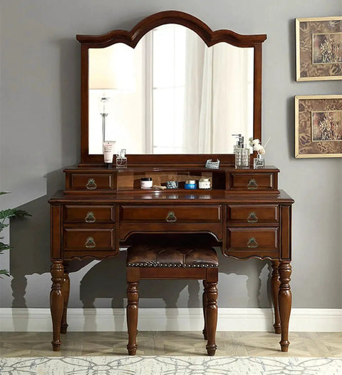 Antique vanity dresser with mirror featuring brass cabinet pulls and leather stool, classic wooden design with vintage accents.