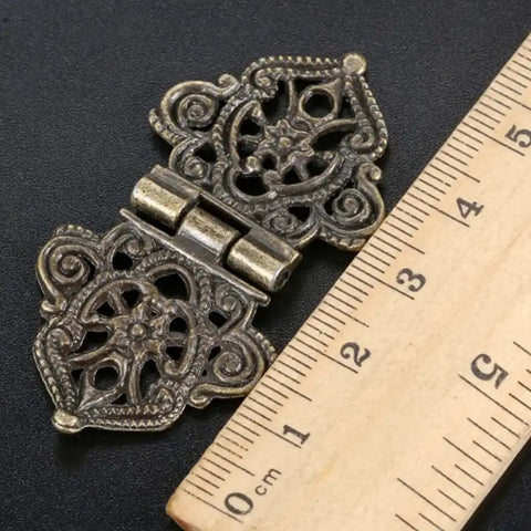 Antique lace hinge with screws beside ruler for scale, part of set of 10 antique lace hinges with screws for doors cabinets drawers and furniture decorative old school hinges for closets cupboards and more durable metal hardware.
