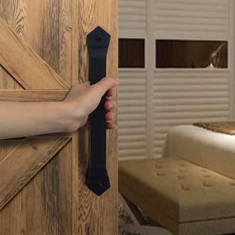 Person holding Barn Door Handle Set Eleven And One Eighth Inch Built Tough Rustic Cast Iron Gate Pulls In Black on wooden door