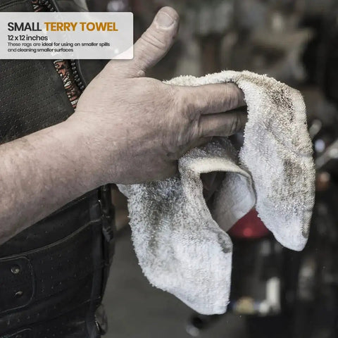 Person holding a white terry rag, 12x12 inches, 100 percent ring spun cotton, shown in a garage setting