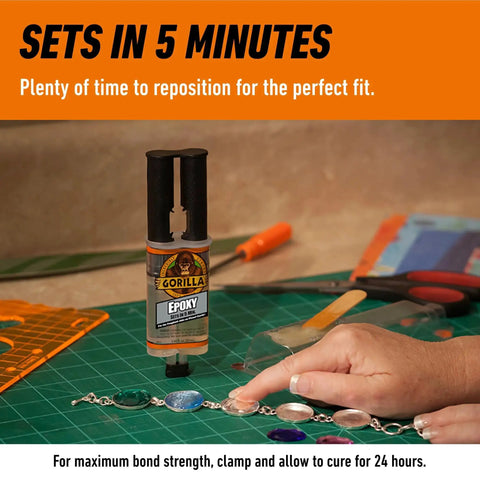 Clear 2 Part Epoxy Syringe, 0.85 Oz, 5 Minute Fast Set, Strong Bond being used to adhere a decorative object on a workbench.