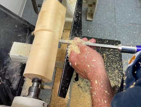 Woodturner using 3 Carbide Wood Turning Tools Set With Rougher Finisher Detailer And 12 Inch Color Coded Solid Aluminum Lathe Tool Handles USA Made For Easy Tool Selection And No Fuss Pro Grade Woodturning Precision to shape wood on lathe.