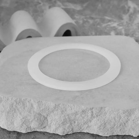 Single silicone gasket on stone surface from Stovetop Espresso Maker Silicone Gasket Six Pack Replacement Seal Ring Compatible With Bialetti Moka Express 9 Cup Imusa 9 Cup Pots And BC 9 Cup Models Durable Coffee Pot Gasket Set.