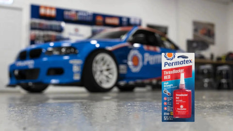 Image of Permatex Red Threadlocker packaging with a blue race car in the background, ideal for cylinder blocks and engine assemblies.