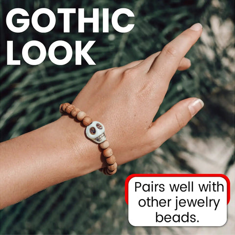 Hand wearing bracelet with 40 Pack 12mm White Skull Beads For Jewelry Making Howlite Skeleton Beads, promoting Gothic look in nature