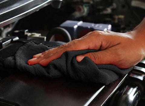 Hand using Shop Towels 50 Pack Black Terry Cloth Rags For Car Detailing And Home Cleaning Beast Absorbent Reusable And Washable
