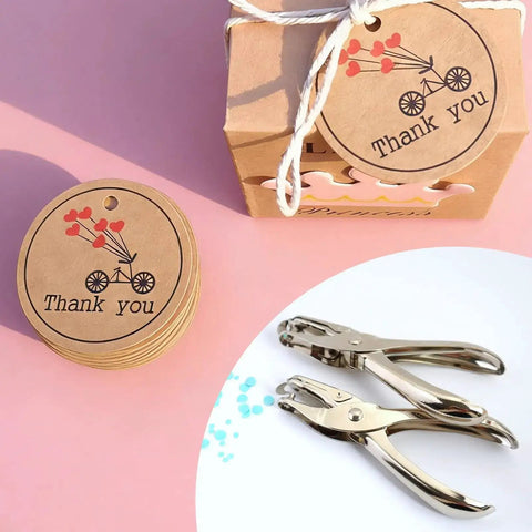 Heavy Duty Handheld Paper Hole Punch for crafters with dual size options, shown with thank you tags and box on a pink background.