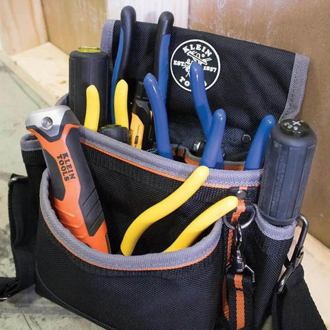 Heavy Duty Folding Jab Saw With Lockback For Drywall in a tool pouch with other hand tools, Klein Tools branding visible.