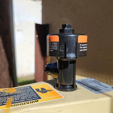 Trucktok high-flow manual relief valve assembly on pool filter housing; black plastic with orange warning labels