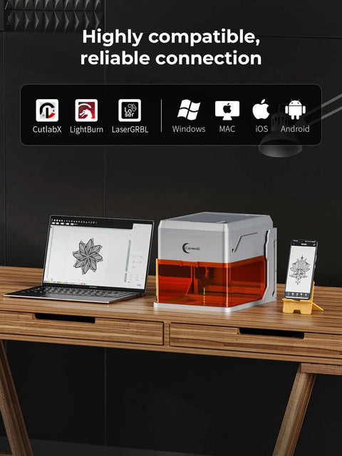 Made For Makers Compact 10W Laser Engraver With Built In Camera on a desk beside a laptop and smartphone displaying engravings.